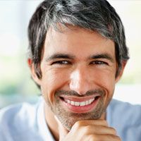 A man smiles after undergoing treatment with sedation dentistry