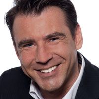 A middle-aged man grins after his smile makeover